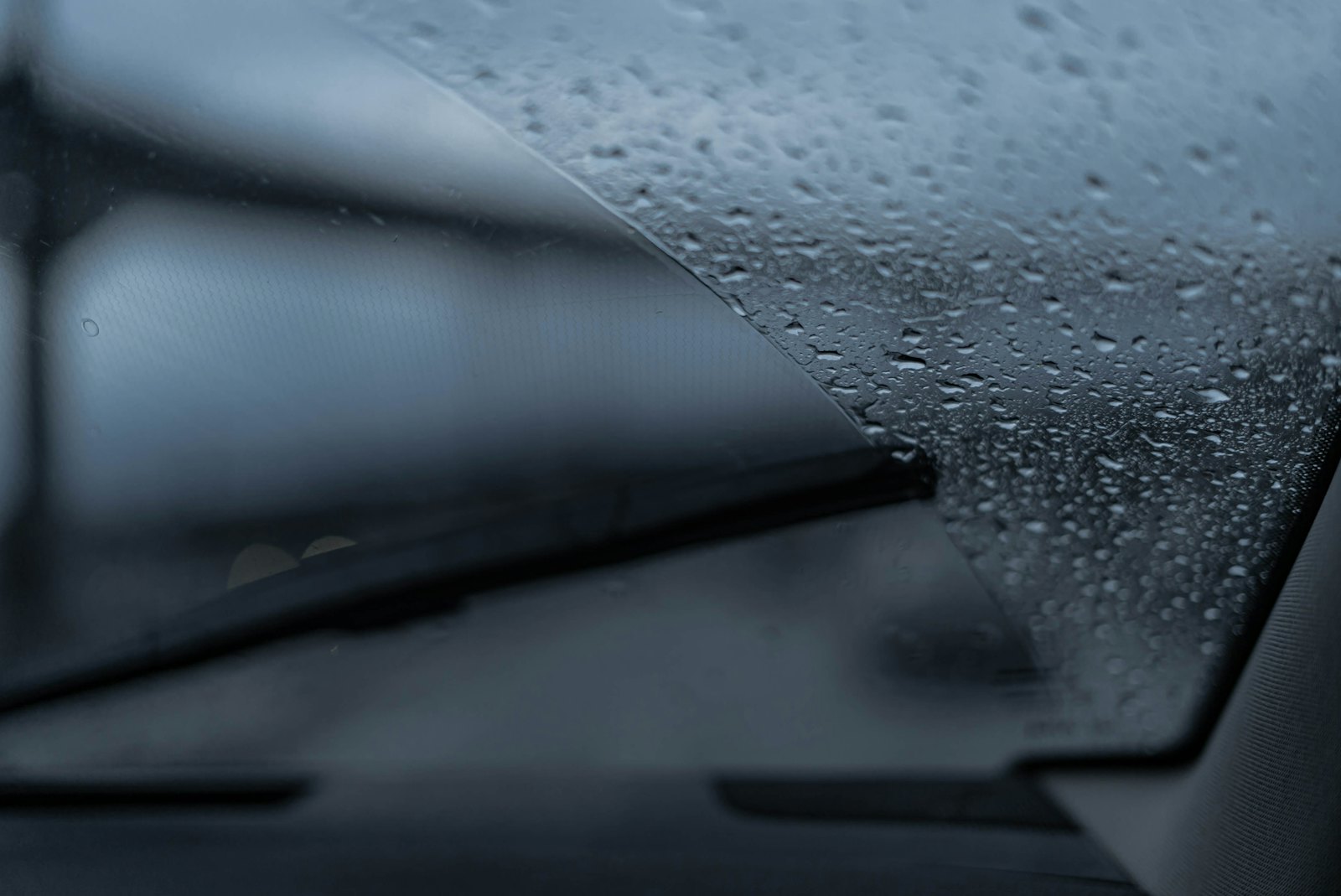 Raindrops on a windscreen, with a wiper blade